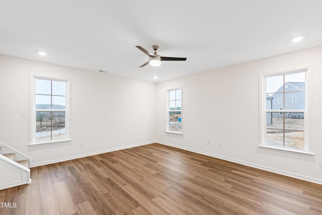 spare room with ceiling fan, plenty of natural light, and light wood-type flooring