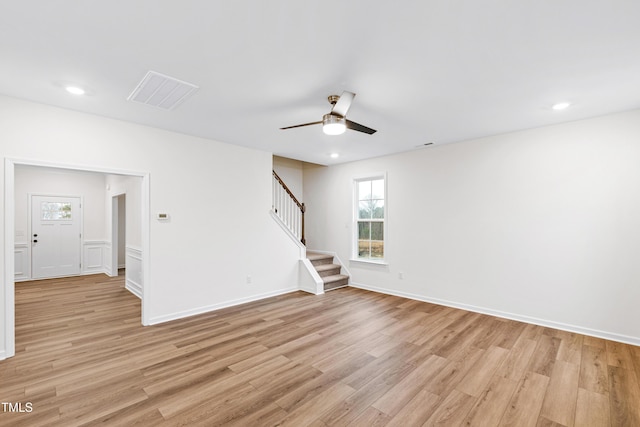 empty room with ceiling fan and light hardwood / wood-style flooring