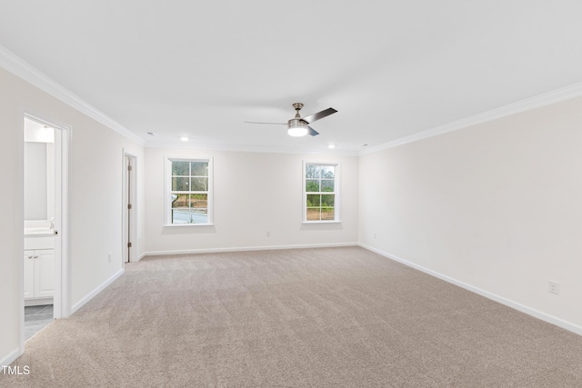 carpeted spare room featuring crown molding and ceiling fan