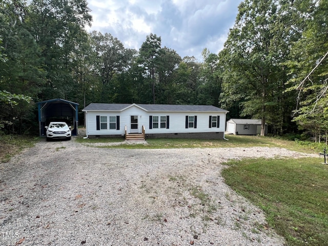 manufactured / mobile home with a storage shed, a front lawn, and a carport