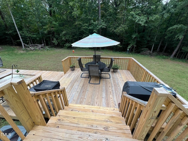 wooden terrace featuring a lawn