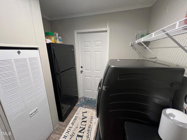 clothes washing area featuring ornamental molding, separate washer and dryer, and hardwood / wood-style floors