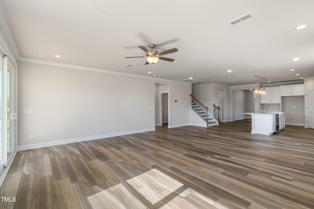 unfurnished living room with crown molding, ceiling fan, and dark wood-type flooring