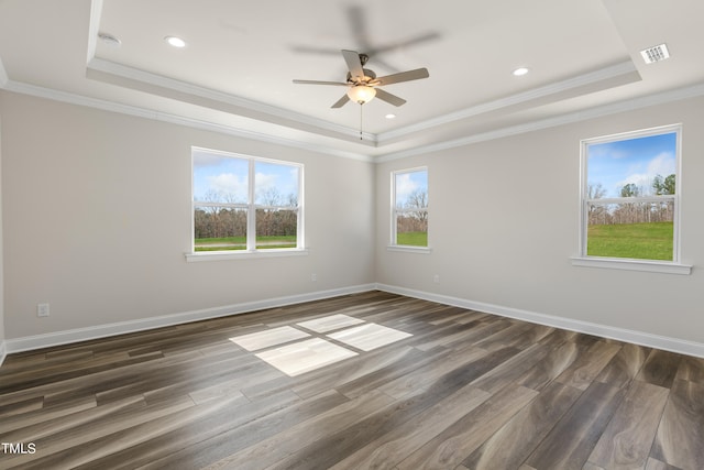 unfurnished room with dark wood-type flooring, a tray ceiling, and ornamental molding