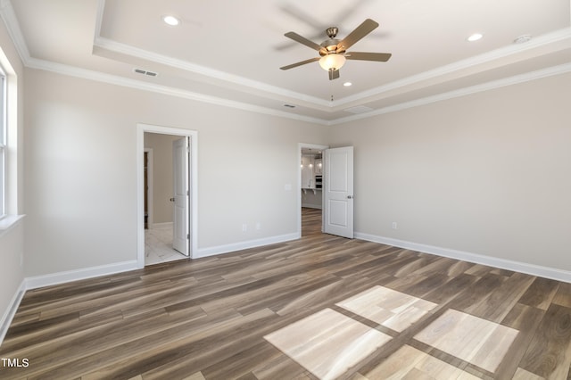 unfurnished bedroom with ceiling fan, dark hardwood / wood-style flooring, a raised ceiling, and crown molding