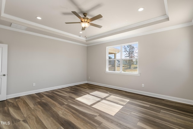 spare room featuring dark hardwood / wood-style flooring, a raised ceiling, ceiling fan, and crown molding