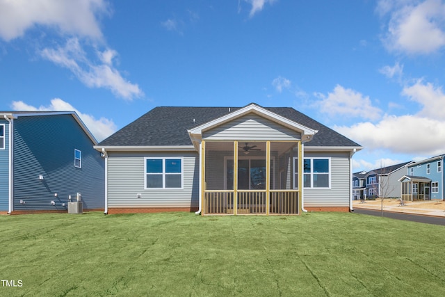 rear view of property featuring a sunroom, ceiling fan, central AC unit, and a lawn