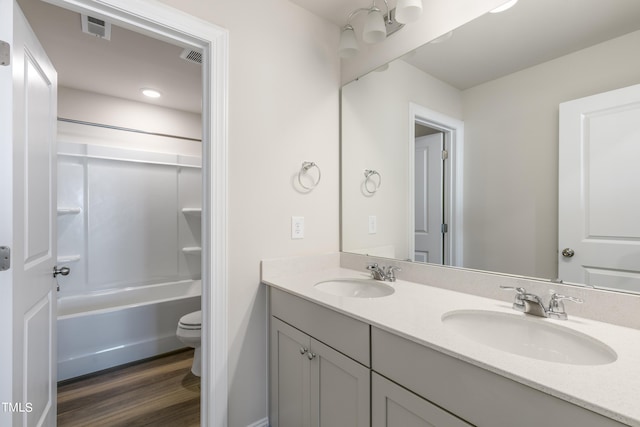 full bathroom with hardwood / wood-style floors, vanity, toilet, and shower / tub combination