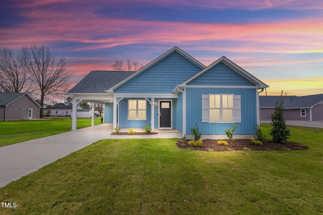 view of front of property with a lawn and a carport