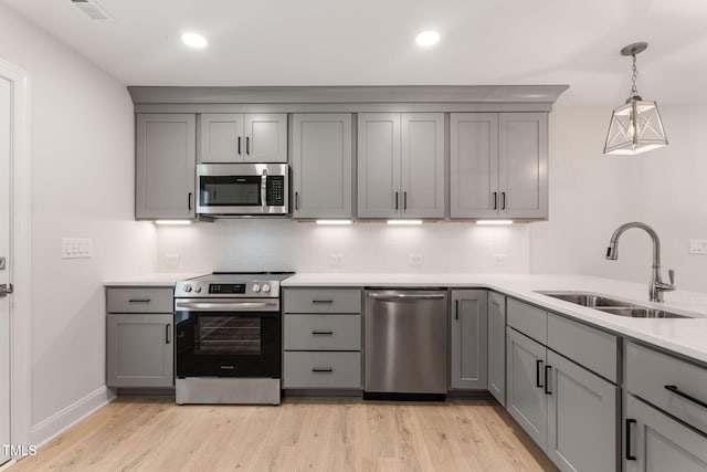 kitchen featuring gray cabinetry, sink, and appliances with stainless steel finishes