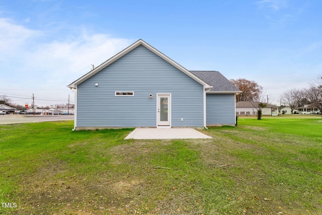 back of house featuring a lawn and a patio area