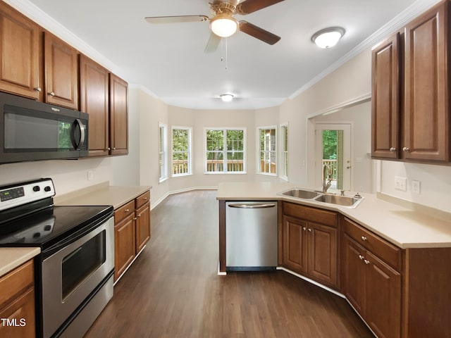 kitchen with appliances with stainless steel finishes, kitchen peninsula, dark hardwood / wood-style flooring, ceiling fan, and sink