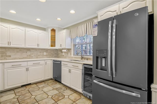 kitchen featuring light countertops, stainless steel refrigerator with ice dispenser, a sink, and white cabinets