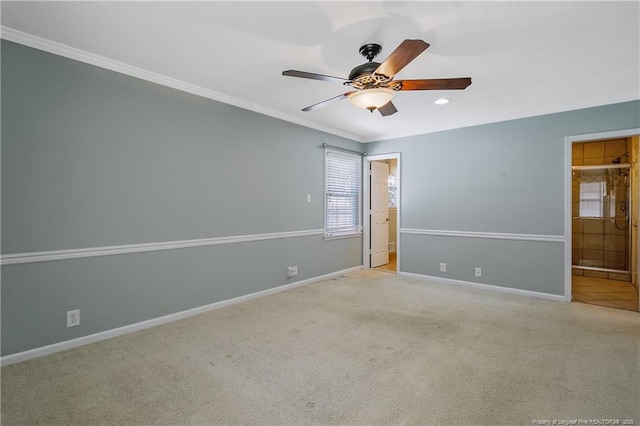 unfurnished room with light carpet, ornamental molding, a ceiling fan, and baseboards