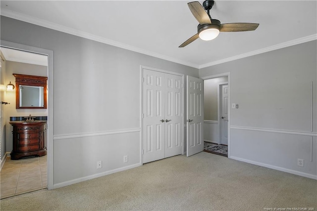 unfurnished bedroom featuring baseboards, crown molding, and light colored carpet