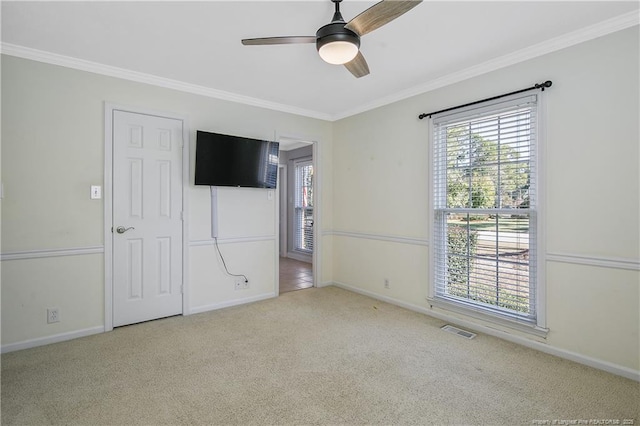 unfurnished bedroom featuring crown molding, visible vents, a ceiling fan, light carpet, and baseboards