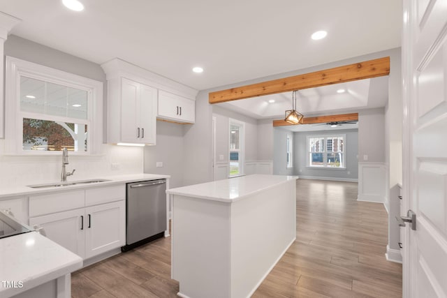 kitchen featuring a center island, white cabinets, sink, stainless steel dishwasher, and ceiling fan