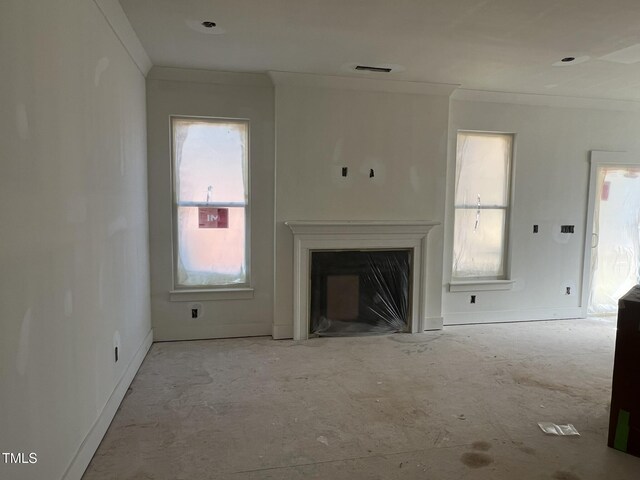 unfurnished living room with ornamental molding