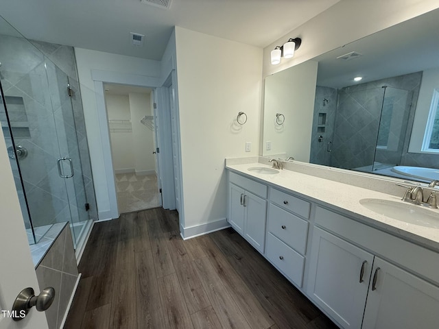 bathroom with hardwood / wood-style flooring, vanity, and an enclosed shower