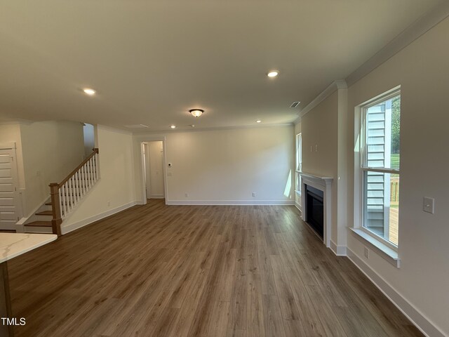 135 Green Haven Blvd Lot # 1, Youngsville, NC 27596 - unfurnished living room with ornamental molding, stairs, wood finished floors, a glass covered fireplace, and baseboards