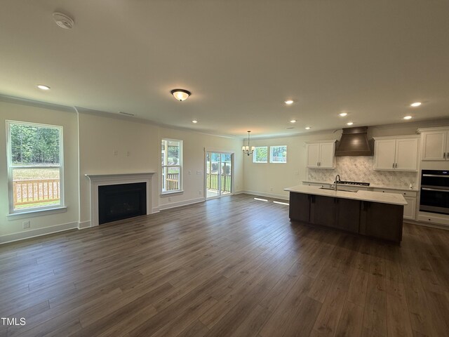 135 Green Haven Blvd Lot # 1, Youngsville, NC 27596 - kitchen featuring open floor plan, premium range hood, light countertops, white cabinetry, and an island with sink