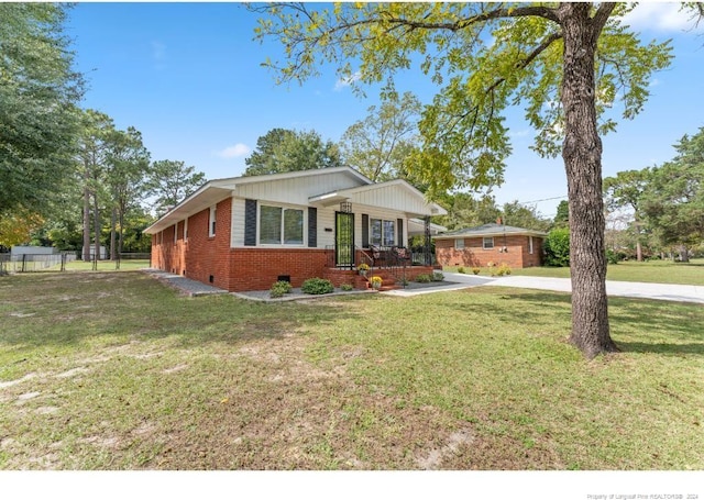 ranch-style house featuring a front lawn and covered porch