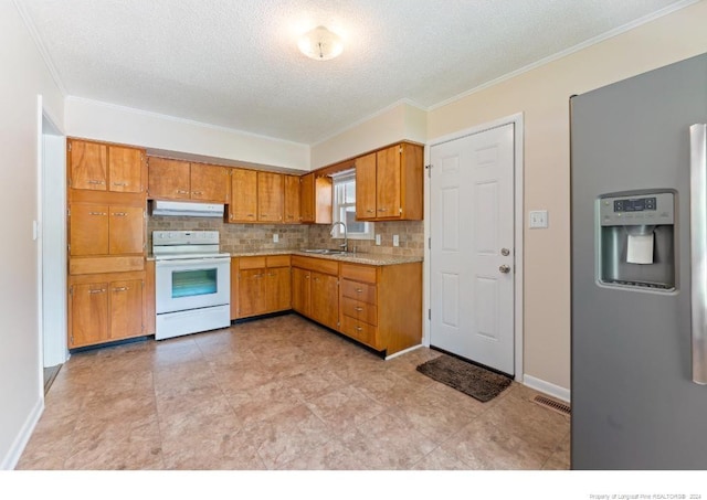 kitchen featuring white electric range oven, sink, a textured ceiling, stainless steel fridge, and decorative backsplash