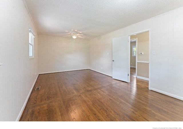 empty room featuring ceiling fan, dark hardwood / wood-style floors, and a healthy amount of sunlight