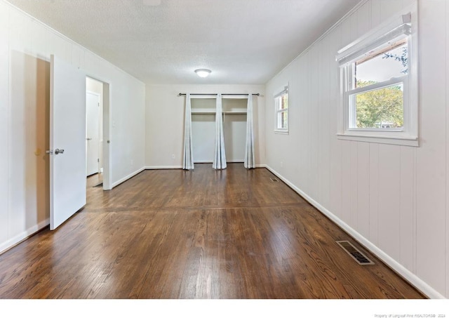 unfurnished bedroom featuring dark wood-type flooring and a textured ceiling