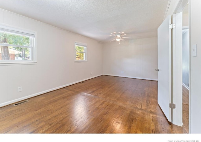 unfurnished room featuring a textured ceiling, wood-type flooring, and ceiling fan