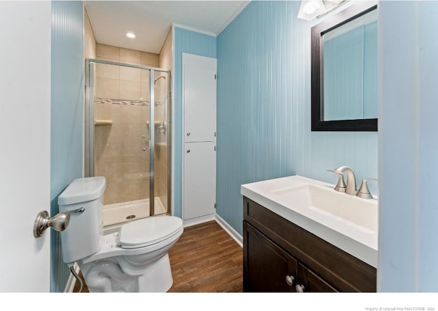 bathroom featuring vanity, hardwood / wood-style flooring, toilet, and a shower with door