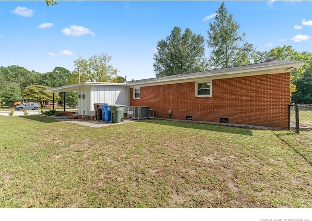 back of house featuring central AC and a yard