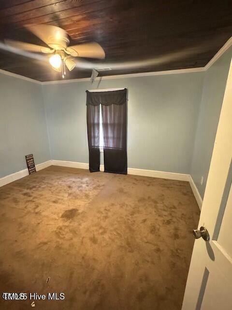 empty room featuring carpet, ceiling fan, wood ceiling, and ornamental molding