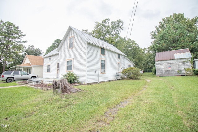 view of side of property featuring a yard and a storage unit