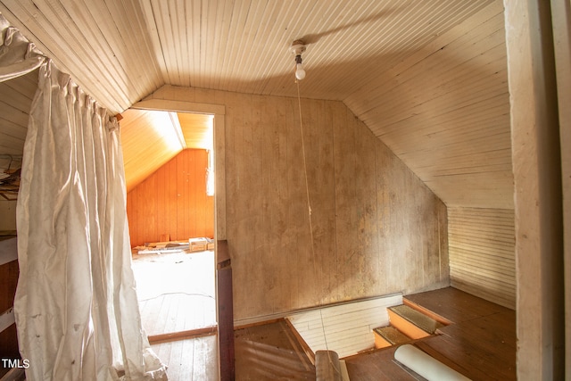 additional living space with wooden ceiling, lofted ceiling, and wood walls