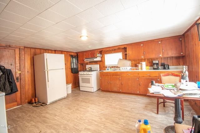 kitchen featuring wooden walls and white appliances