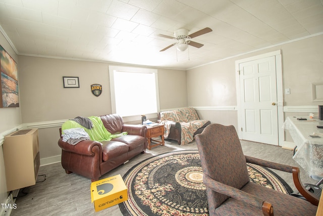 living room with crown molding, ceiling fan, and light hardwood / wood-style flooring