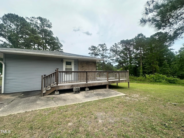 rear view of house with a lawn and a deck