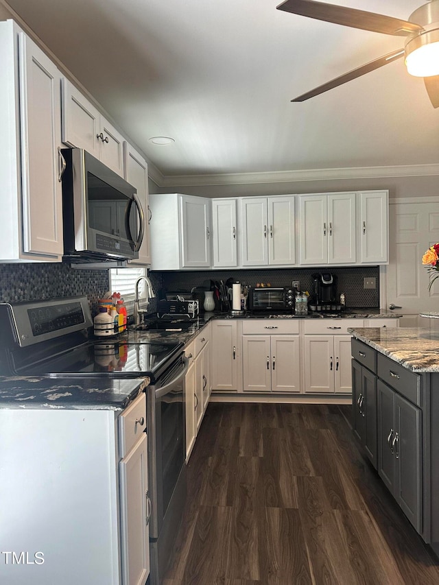 kitchen featuring appliances with stainless steel finishes, white cabinets, backsplash, dark hardwood / wood-style flooring, and ceiling fan