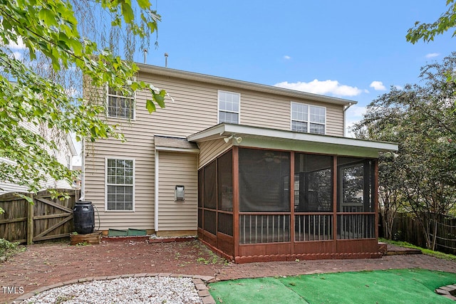 rear view of house featuring a sunroom