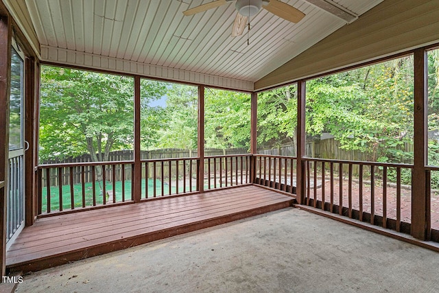 unfurnished sunroom with ceiling fan, wooden ceiling, plenty of natural light, and vaulted ceiling