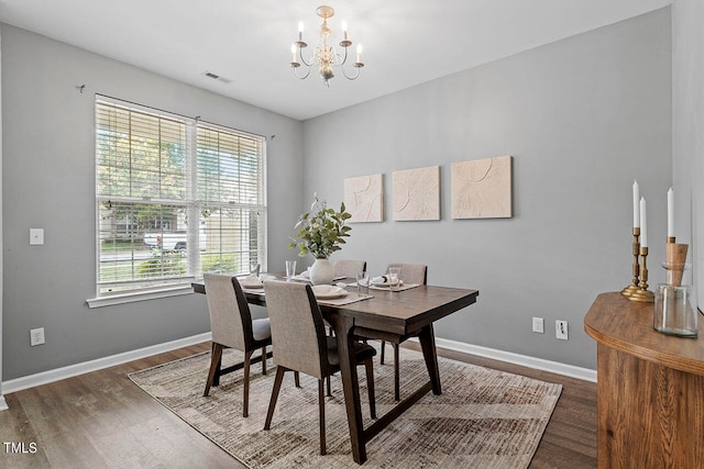 dining room with a notable chandelier, a healthy amount of sunlight, and dark hardwood / wood-style floors