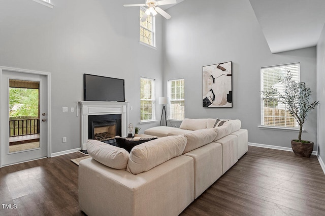 living room featuring high vaulted ceiling, dark hardwood / wood-style flooring, and plenty of natural light