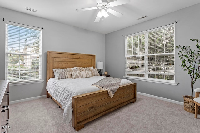 carpeted bedroom featuring ceiling fan and multiple windows