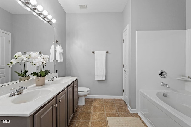 bathroom with a bath, toilet, and vanity