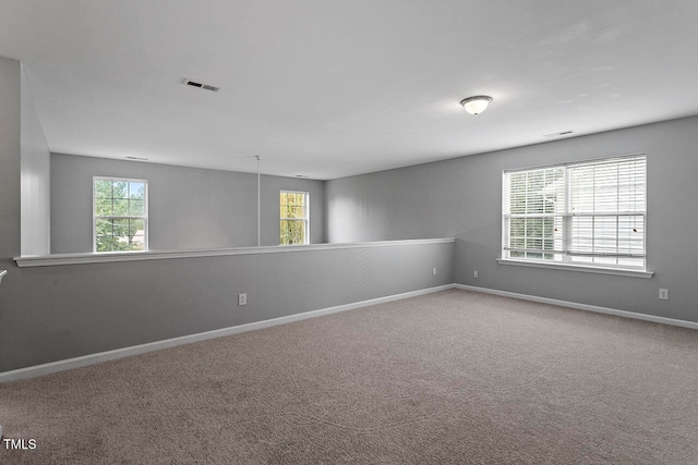 carpeted spare room featuring a healthy amount of sunlight