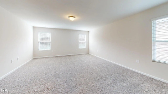 carpeted empty room featuring a wealth of natural light