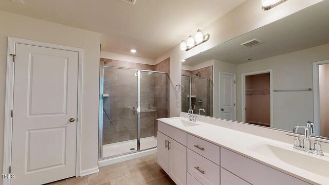 bathroom with tile patterned flooring, an enclosed shower, and vanity