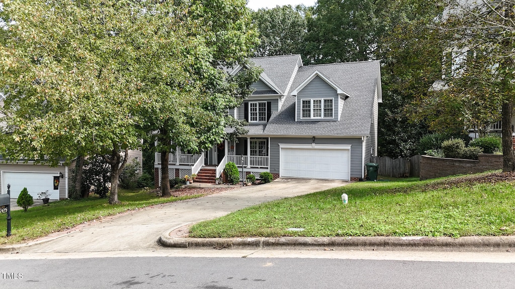 view of front facade featuring a porch, a garage, and a front yard