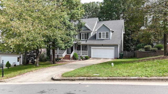 view of front facade featuring a porch, a garage, and a front yard